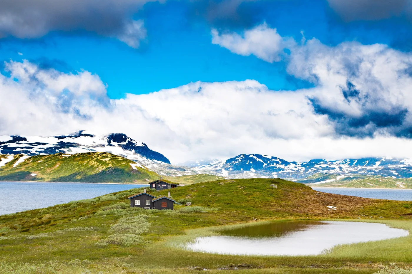 Kék fjord és hófedte norvég hegyek